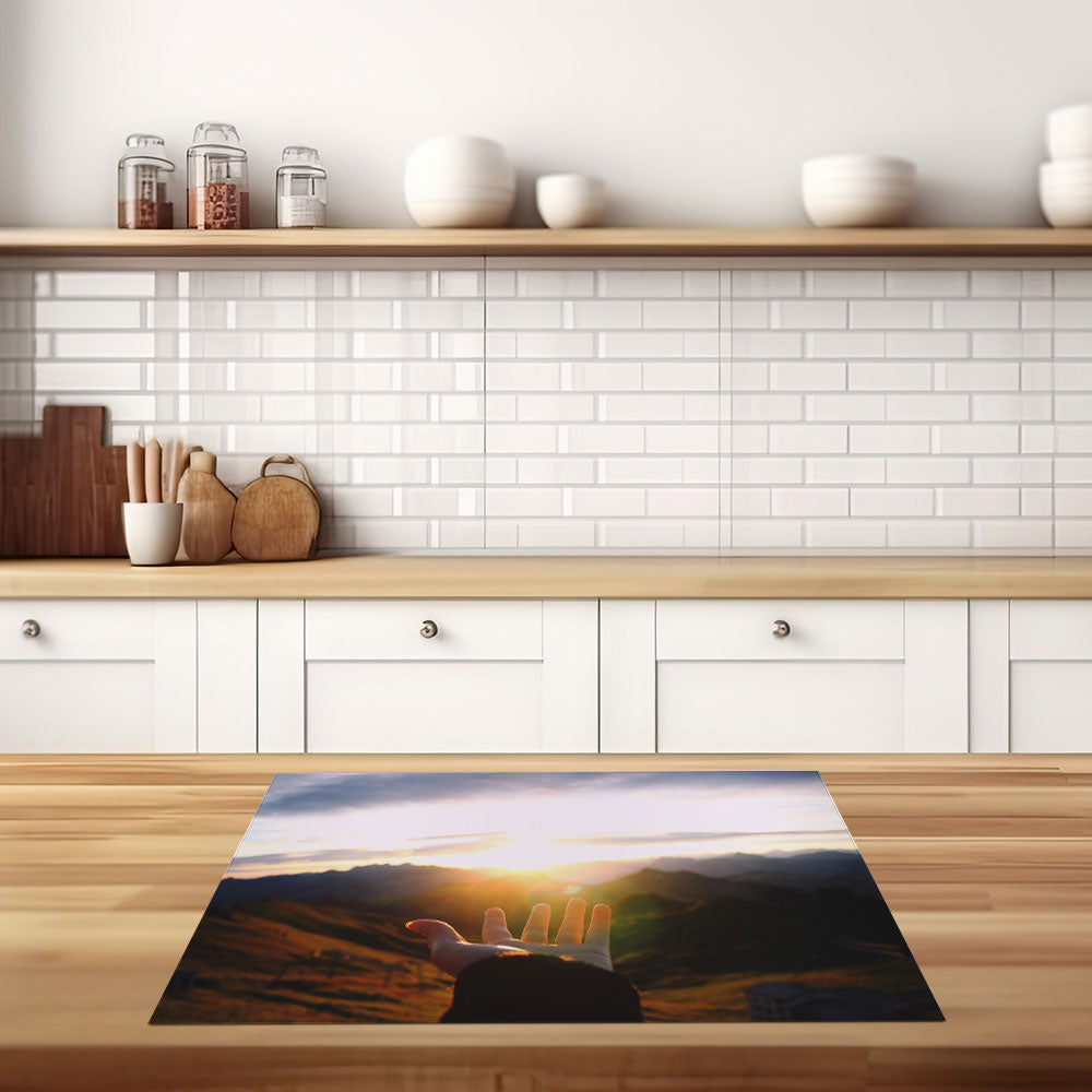 inductiebeschermer hand naar zonsondergang keuken