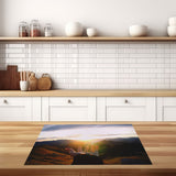 inductiebeschermer hand naar zonsondergang keuken